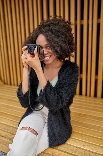 Kręcone włosy fotograf kobieta z aparatem fotograficznym w rękach — Zdjęcie stockowe