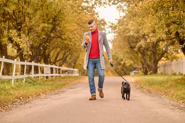 Hombre caminando con un perro en un parque — Foto de Stock