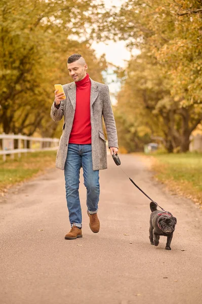 Homem caminhando com um cão em um parque — Fotografia de Stock