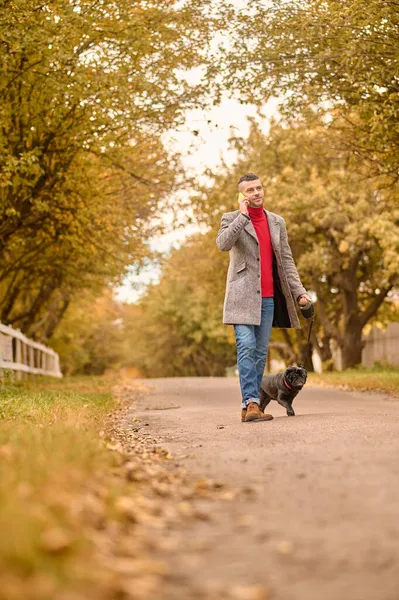 Homem caminhando com um cão em um parque — Fotografia de Stock