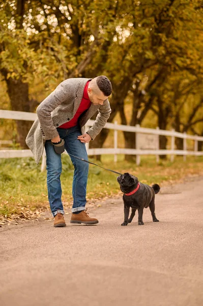 Un homme avec un chien dans le parc d'automne — Photo