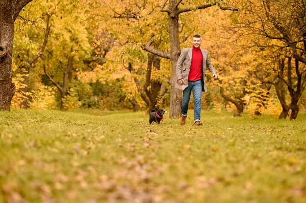 A man playing with his dog in the park — Stock Photo, Image