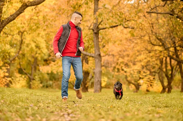 Un hombre jugando con su perro en el parque — Foto de Stock