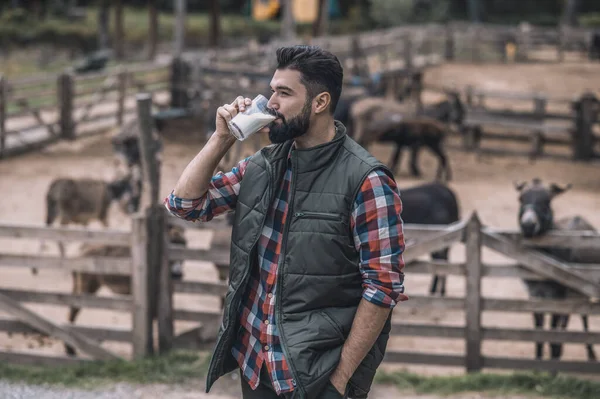 Un fermier barbu tenant un verre de lait — Photo