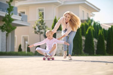 Annem kaykay yaparken bir kıza destek oluyor.