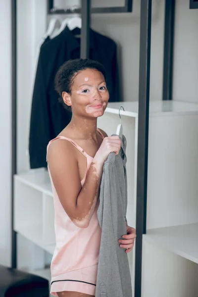 Een mooie jonge vrouw die kleren kiest uit haar garderobe — Stockfoto