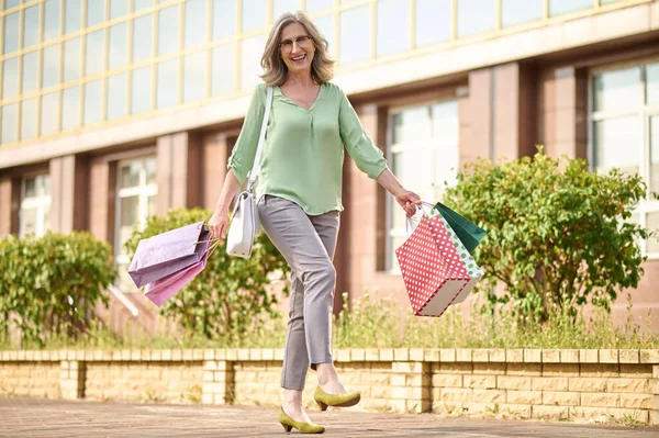 Kobieta z zakupami idąc ulicą — Zdjęcie stockowe