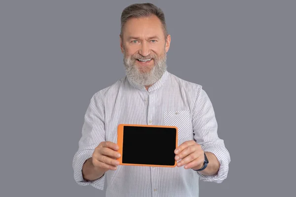 Um homem segurando um tablet nas mãos — Fotografia de Stock