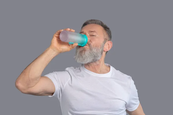 Bearded man holding a bottle of water — Stock Photo, Image