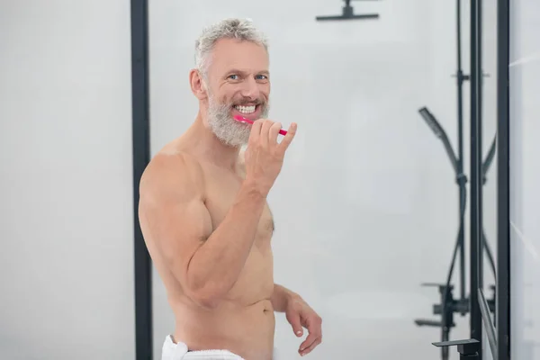 Homem de cabelos brancos segurando escova de dentes escovação dentes — Fotografia de Stock