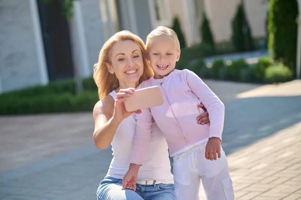 Mujer joven y una chica haciendo selfie —  Fotos de Stock
