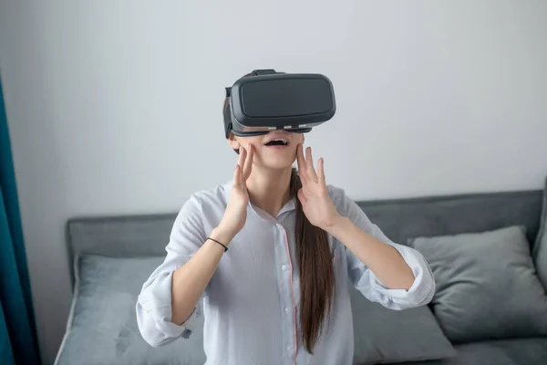 Öppen mun långhårig vit kvinna utforskar virtuell verklighet — Stockfoto