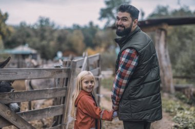 Çiftçi ve kızı el ele yürüyorlar.