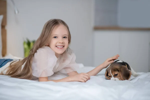 Alegre adorável menina acariciando seu filhote de cachorro — Fotografia de Stock