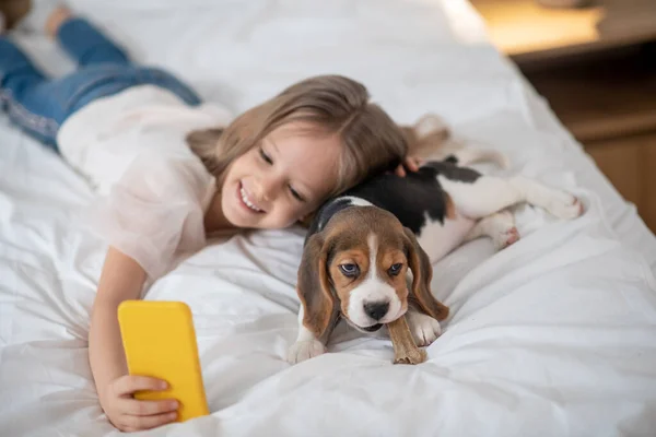 Adorável menina tomando selfie com seu beagle engraçado — Fotografia de Stock