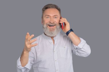 Elinde akıllı telefon olan olgun bir adam.