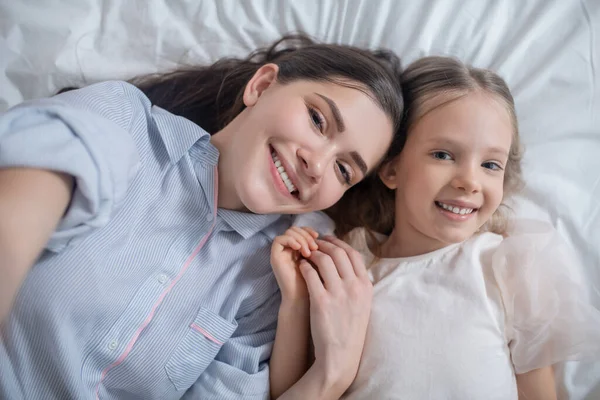 Criança alegre e sua mãe atraente posando para a câmera — Fotografia de Stock