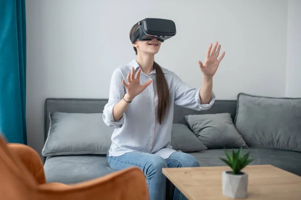 Sonriente mujer sorprendida jugando una simulación 3D juego — Foto de Stock