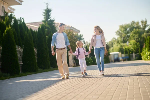 Padres y su hija caminando y tomados de la mano — Foto de Stock