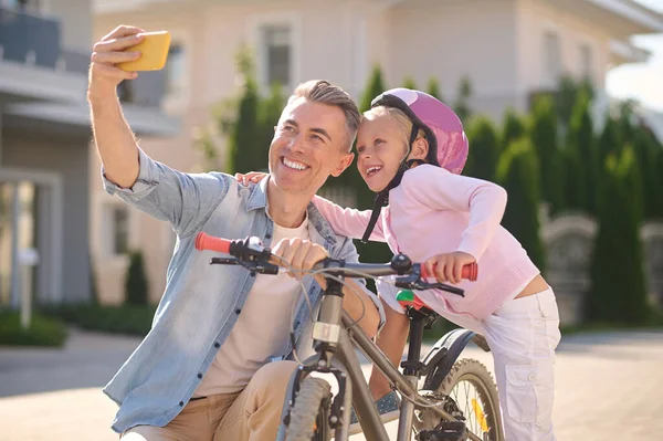 子供と自転車で自撮りしてる笑顔の男 — ストック写真