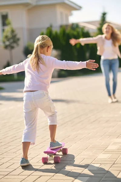 Une fille blonde essayant le skateboard et se sentant excitée — Photo