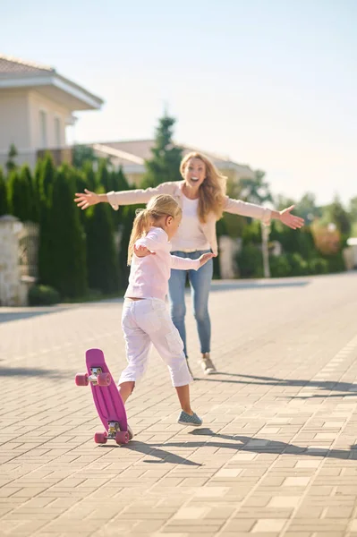 Uma menina loira tentando skate e sentindo-se animado — Fotografia de Stock