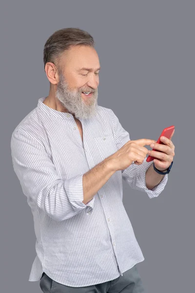 Mature man with a smartphone in hands — Stock Photo, Image
