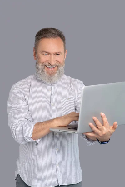 Bärtiger Mann arbeitet mit seinem Gerät — Stockfoto