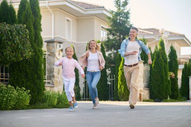 Genç bir aile yürüyor ve eğleniyor.