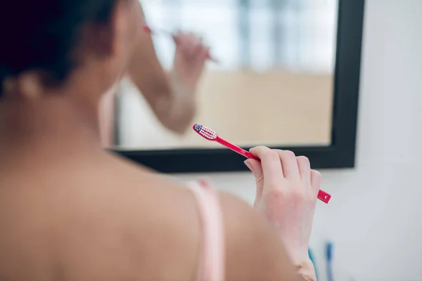 Een close-up van een vrouw met een tandenborstel in handen — Stockfoto