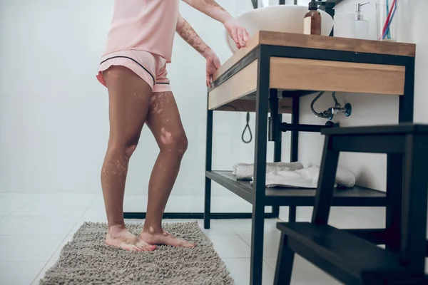 Een close-up van een vrouw in roze lingerie in een badkamer — Stockfoto