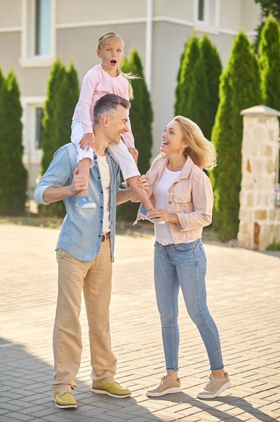 Dad carrying a girl on his shouldres during family walk — Stock Photo, Image