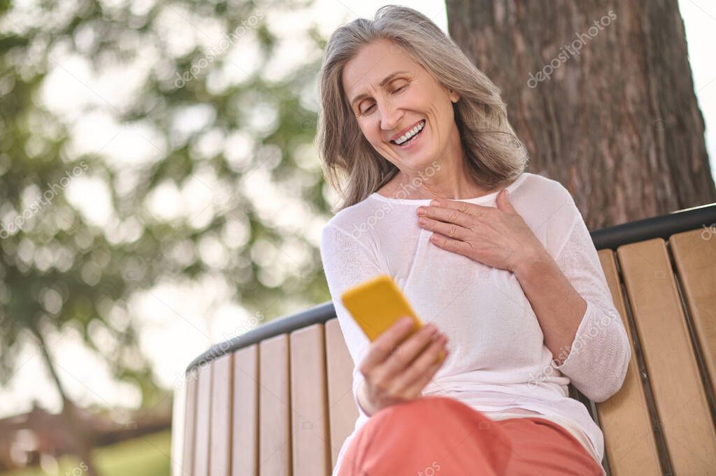 Woman talking looking into smartphone screen outdoors