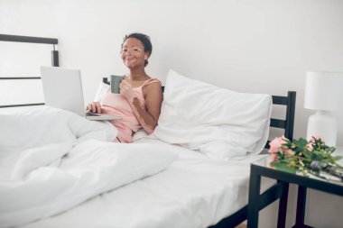 Evde dizüstü bilgisayarı olan genç bir kadın.