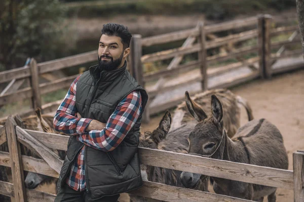 Jovem agricultor de cabelos escuros perto do curral — Fotografia de Stock