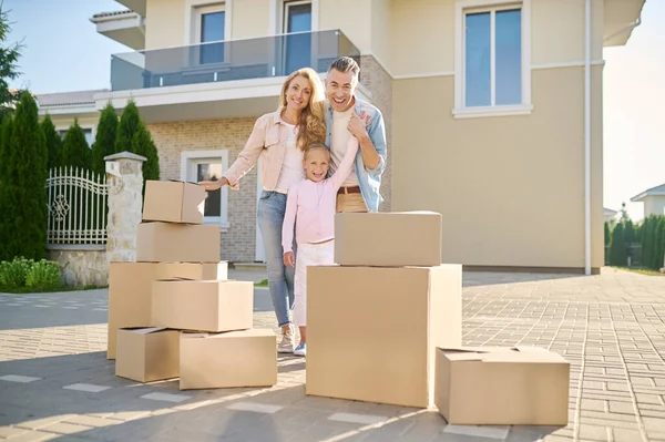 Yeni bir eve taşınırken karton kutuları açan sevimli bir aile. — Stok fotoğraf