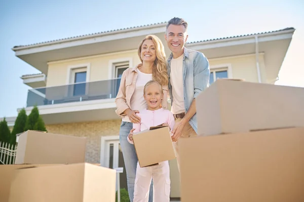Linda familia desempacar cajas de cartón mientras se muda a una nueva casa — Foto de Stock