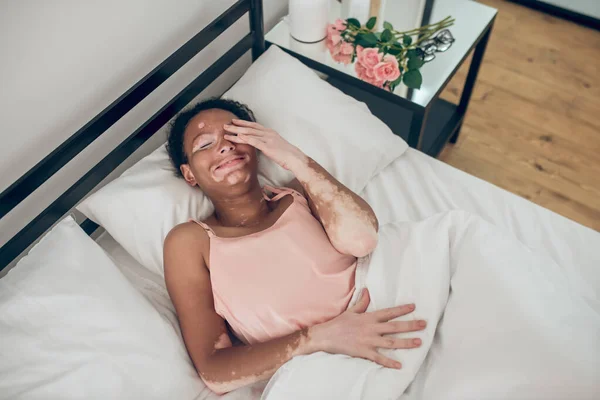 Una joven mujer de piel oscura acostada en la cama — Foto de Stock