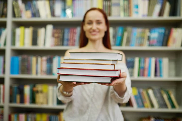 Mujer estirando pila de libros a cámara —  Fotos de Stock