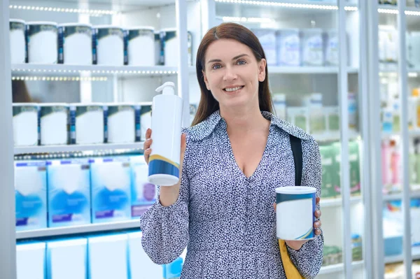 Pretty woman choosing body care products in a drugstore — Stock Photo, Image