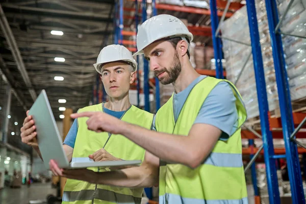 Dos hombres trabajando mirando juntos la pantalla del portátil — Foto de Stock