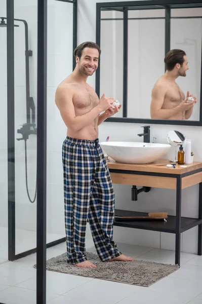Ένας άντρας με καρό παντελόνι στέκεται στον καθρέφτη. — Φωτογραφία Αρχείου