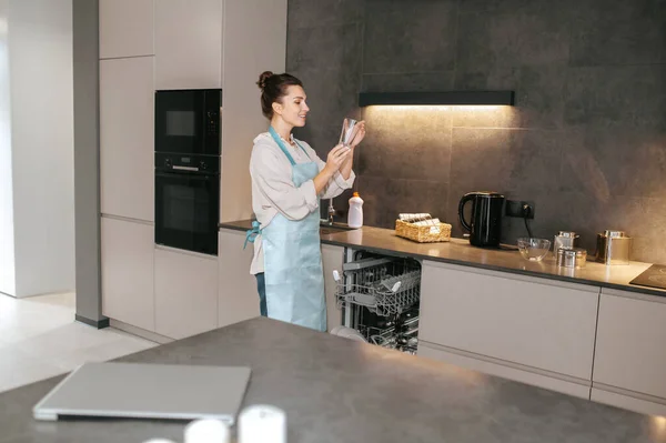 Mujer sosteniendo vasos lavado glaases y escrutinio ellos — Foto de Stock