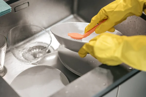 Imagen de cerca de las manos en guantes lavando platos — Foto de Stock