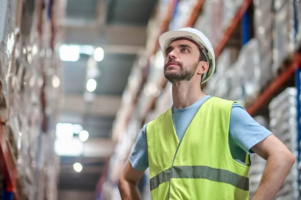 Man in overall met handen op de riem kijkend omhoog — Stockfoto