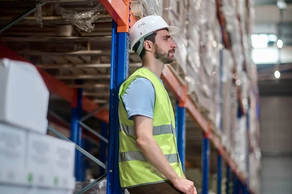 Profiel van de mens in werkkleding leunend tegen metalen toonbank — Stockfoto