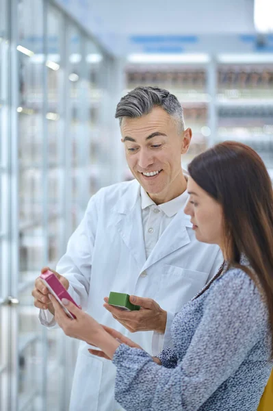 Especialista masculino consultando um cliente sobre produtos de cuidados com o corpo — Fotografia de Stock