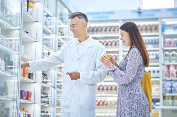 Männlicher Apotheker berät einen Kunden in einer Drogerie — Stockfoto