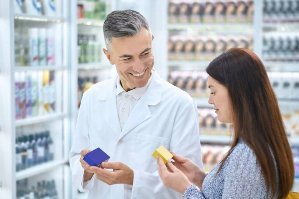 Männlicher Apotheker berät einen Kunden in einer Drogerie — Stockfoto