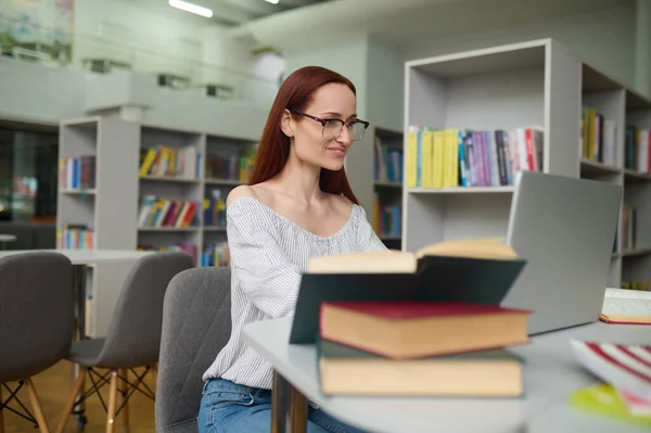 図書館のノートパソコンで働く眼鏡の女性 — ストック写真